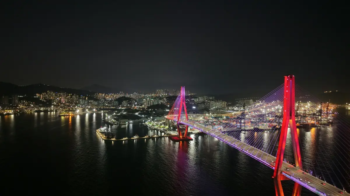 Illuminated suspension bridge over water at night