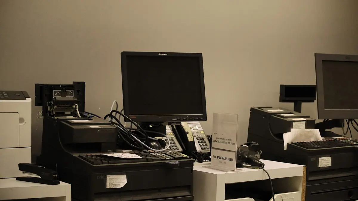 Multiple cash registers with computer monitors at a checkout counter
