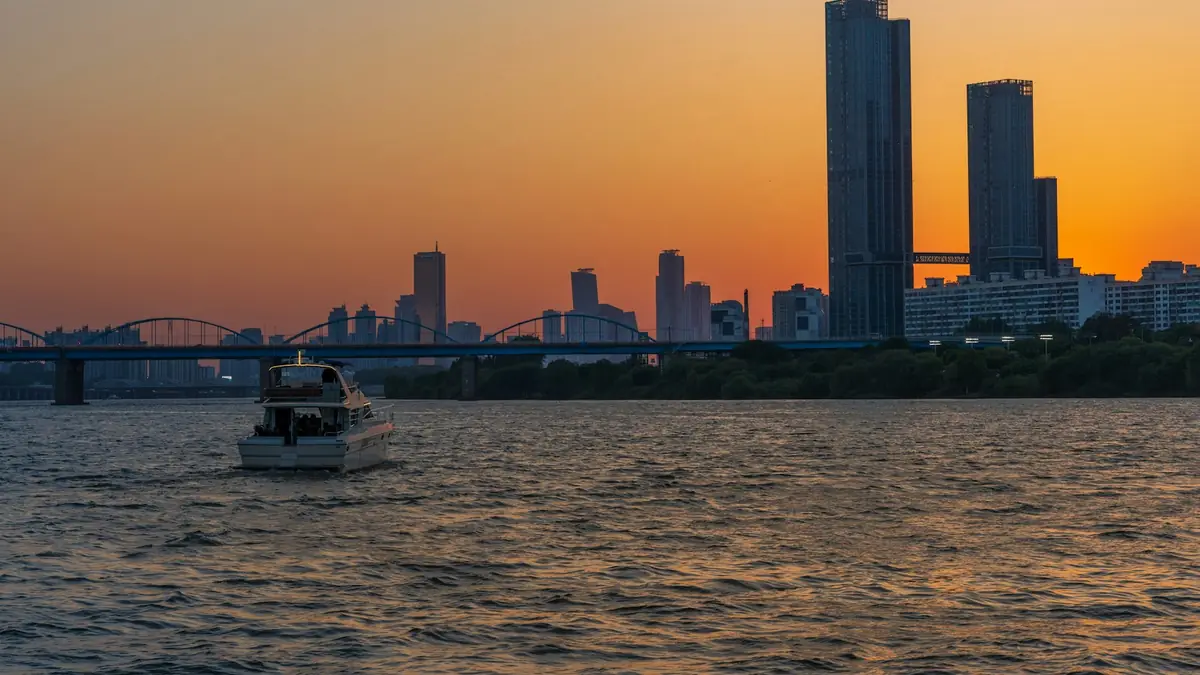a boat in a body of water with a city in the background