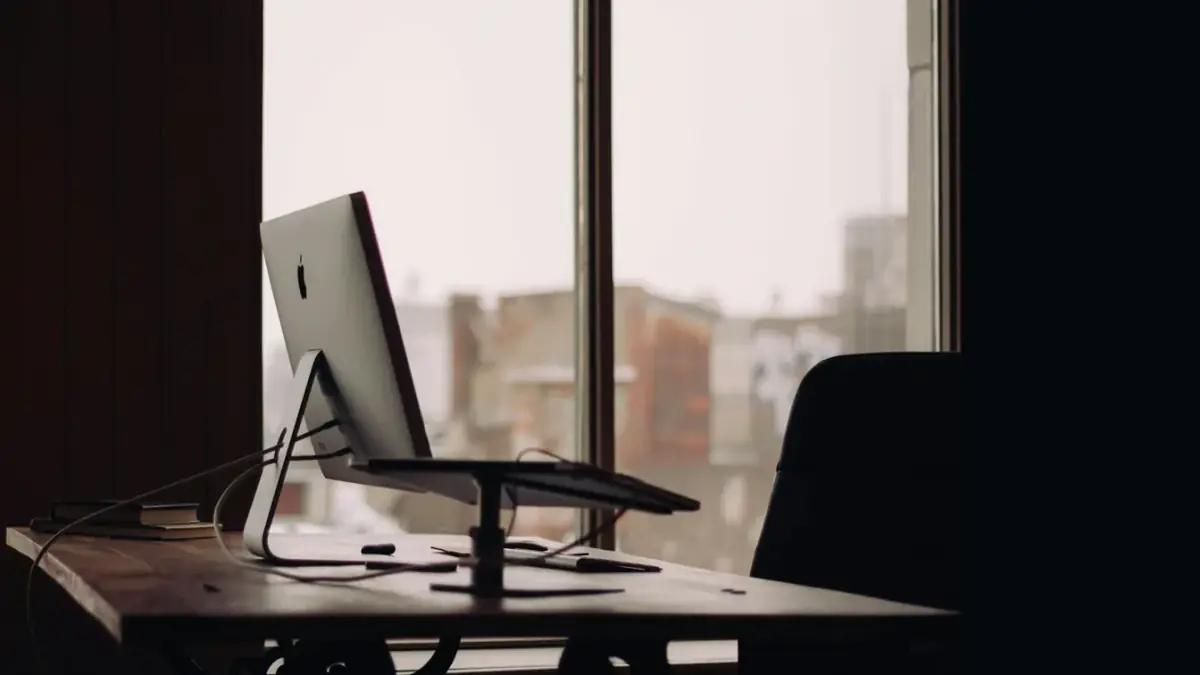 silver iMac on desk inside office