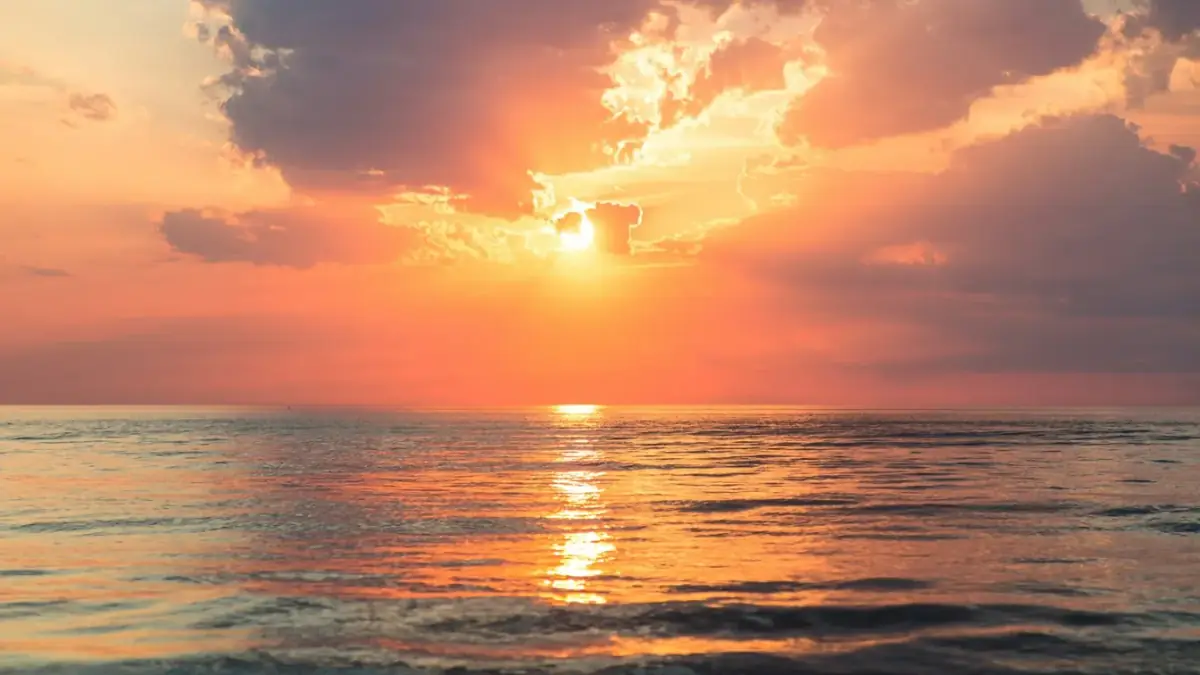 sea under white clouds at golden hour