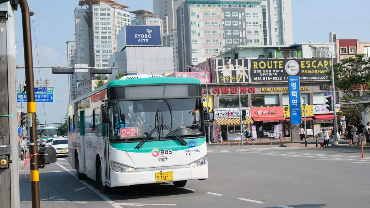 평택역 앞 도로를 달리는 시내버스와 상가 건물