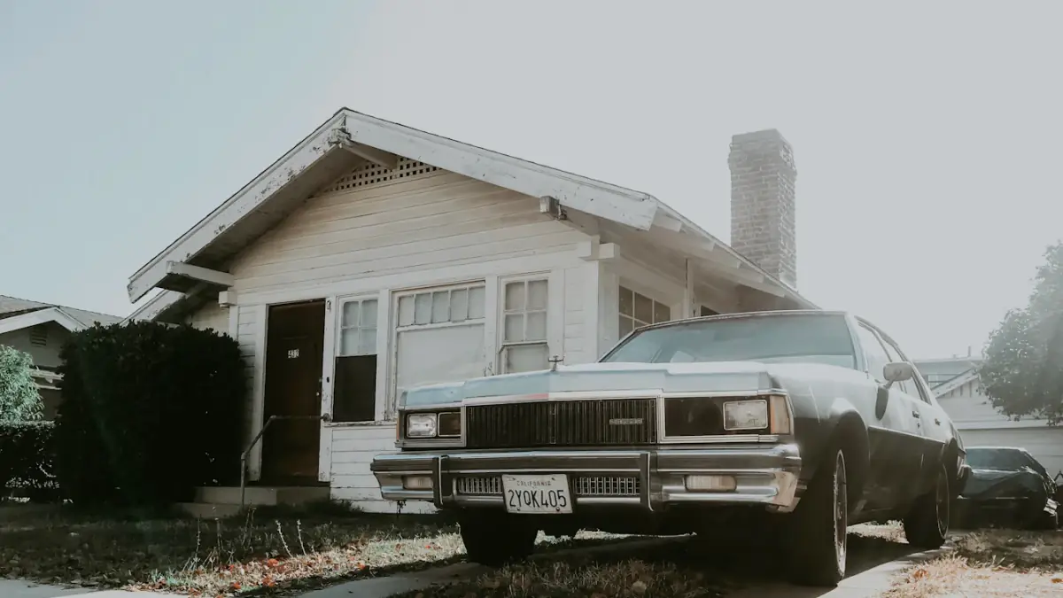 black sedan parked beside house